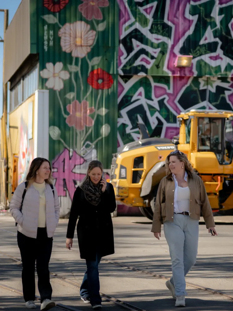 People walking through a vibrant urban area in Gothenburg with colorful street art.